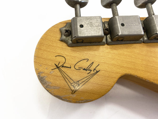 Close-up of vintage Dennis Gadsby signature and vintage metal tuning pegs on worn maple guitar headstock