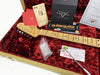 Fender Stratocaster guitar neck with maple fretboard inside a red plush-lined tweed case, surrounded by Fender Custom Shop care cards, warranty documents, tremolo spring instructions, a guitar receipt, and a tremolo arm.