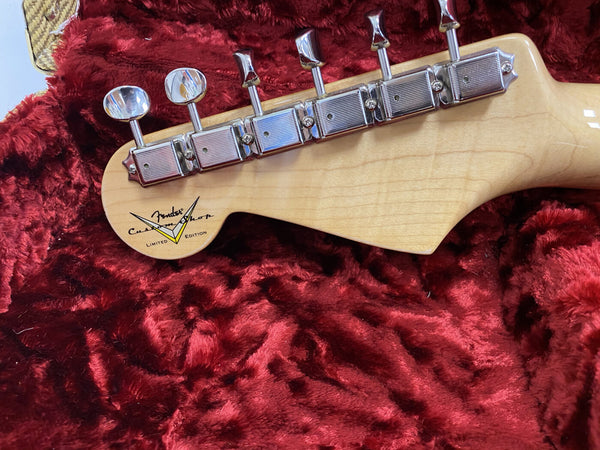 Close-up of Fender Custom Shop Limited Edition guitar headstock with six chrome tuning pegs on red plush case interior