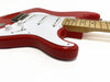 Close-up of red electric guitar with white pickguard, maple neck, three single-coil pickups, tone and volume control knobs, and tremolo bridge on white background