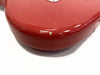 Close-up of red electric guitar body corner showing paint chips and wear on glossy finish