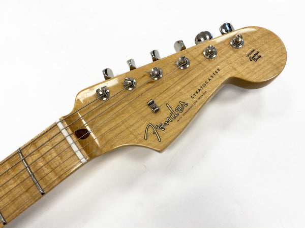 Close-up of Fender Stratocaster electric guitar maple neck and headstock with chrome tuning pegs and original contour body logo on white background