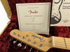 Fender Telecaster guitar headstock with tuning pegs and Certificate of Authenticity inside red plush guitar case