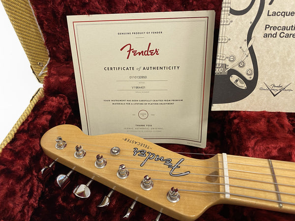 Fender Telecaster guitar headstock with tuning pegs and Certificate of Authenticity inside red plush guitar case