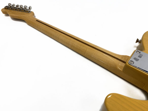 Maple neck and headstock of a yellow electric guitar with chrome tuning pegs and a skunk stripe on the back of the neck against a white background.
