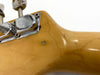 Close-up of vintage guitar tuning pegs and maple neck showing natural wood grain and finish imperfections