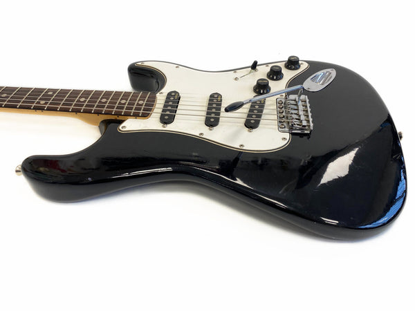 Black solid body electric guitar with white pickguard and three single-coil pickups, maple neck, and rosewood fretboard on white background