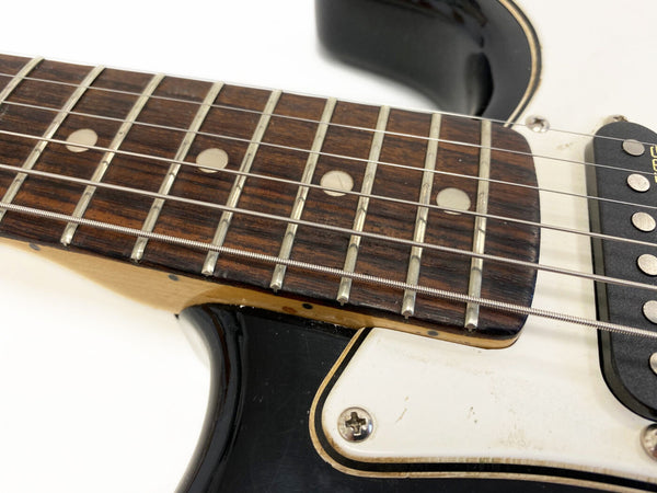 Close-up of electric guitar fretboard with dot inlays, metal frets, and steel strings, featuring black body and white pickguard with visible screw for Coffee House Guitars product listing.