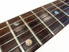 Close-up of dark rosewood guitar fretboard with abalone dot inlays and metal frets on Coffee House Guitars acoustic guitar
