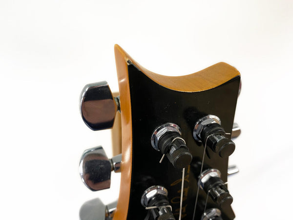 Close-up image of guitar headstock with tuning pegs and strings on a wooden neck against a white background