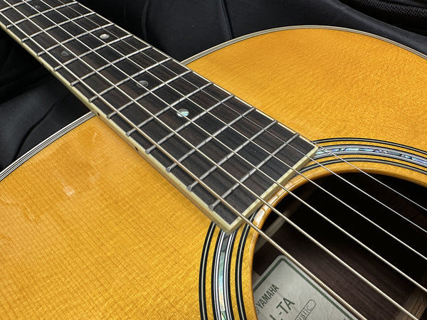 Close-up of Yamaha LL-TA acoustic guitar spruce top, rosewood fretboard, and abalone rosette detail