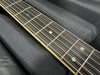 Close-up of acoustic guitar rosewood fretboard with metal frets and pearl dot inlays on black fabric background
