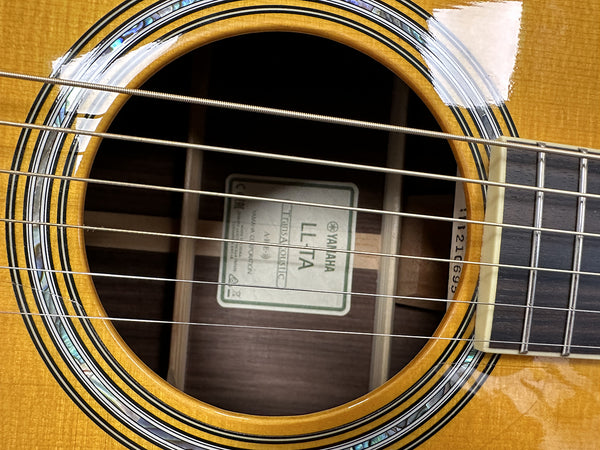 Close-up of Yamaha LL-TA acoustic guitar soundhole showing rosette and strings.