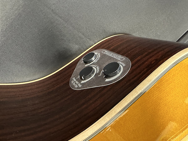 Close-up of acoustic guitar control panel with TransAcoustic effects including reverb, chorus, and line out volume knobs on wood grain finish guitar body