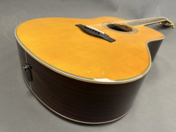 Close-up of acoustic guitar body with natural wood top and dark wood sides showing chip on edge, Coffee House Guitars product listing
