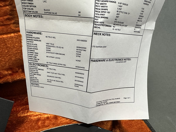 Close-up of limited edition certificate detailing hardware and electronics specifications for a 63 Telecaster guitar, including bridge, pickups, knobs, and control switch information.