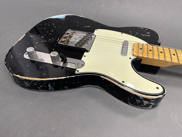 Black vintage relic Telecaster electric guitar with white pickguard and maple neck on gray background