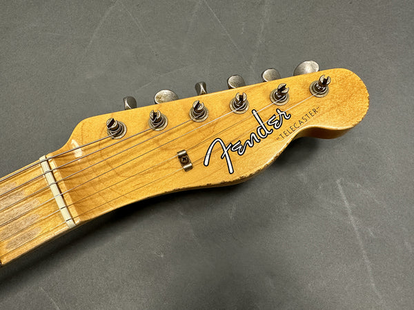 Close-up of vintage Fender Telecaster guitar headstock with tuning pegs and strings on gray background