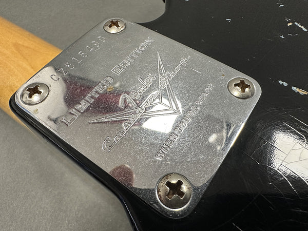Close-up of Fender Limited Edition Custom Shop neck plate on black electric guitar body with visible serial number C2515490 and signs of wear
