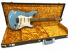 Vintage Fender Stratocaster electric guitar with worn light blue finish and maple fretboard displayed in plush yellow Fender hard case