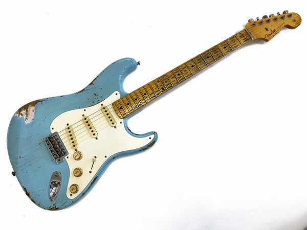 Vintage Fender Stratocaster electric guitar in distressed surf green finish with maple neck and white pickguard, showing wear and aging signs