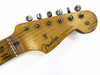 Close-up of vintage Fender Stratocaster guitar headstock with aged wood finish and silver tuning pegs on white background