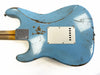 Back of vintage light blue electric guitar with heavy worn and distressed finish showing wood underneath, white plastic backplate, and maple neck with four-bolt metal neck plate against white background