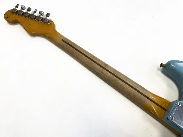 Vintage electric guitar neck and headstock with tuning pegs, showing worn wood finish and neck stripe on light blue body background