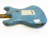 Back of light blue electric guitar body with visible wear and scratches, showing neck joint plate and white plastic backplate on plain white background