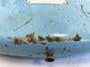 Close-up of light blue electric guitar body with heavy paint wear and chipping revealing wood beneath near strap button