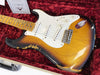 Vintage Fender Stratocaster electric guitar with sunburst finish and maple neck in red velvet-lined hard case
