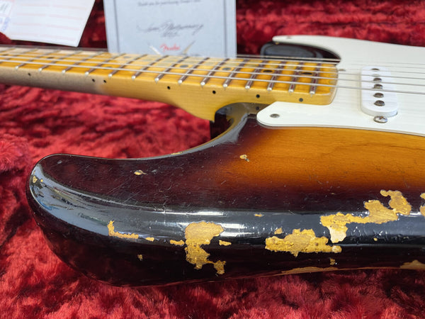 Close-up of vintage sunburst electric guitar body showing wear and paint chipping, maple neck with dot inlays, white pickguard, displayed on red plush fabric at Coffee House Guitars