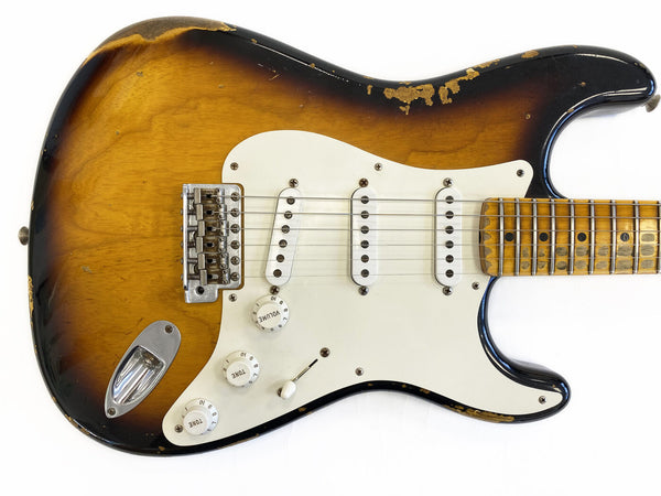 Vintage sunburst electric guitar with three single-coil pickups and white pickguard showing wear and relic finish