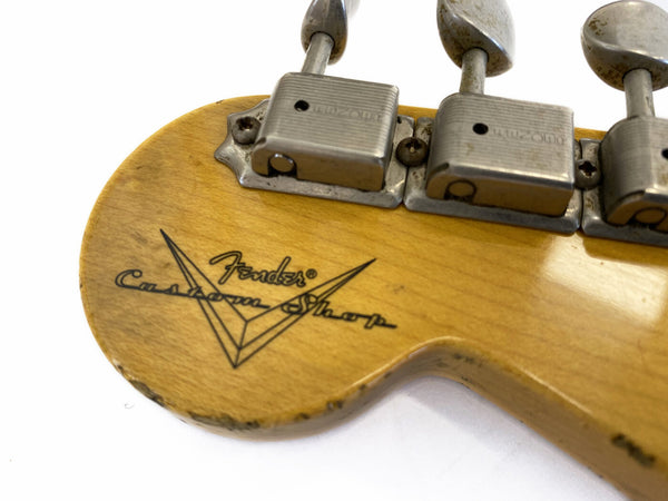 Close-up of Fender Custom Shop guitar headstock with vintage tuning pegs and worn natural wood finish