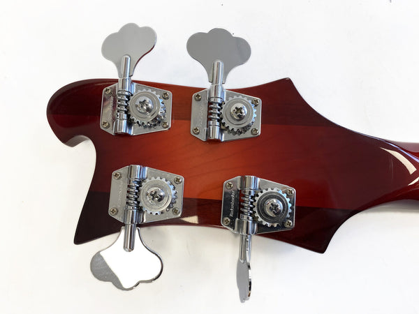 Close-up of Rickenbacker bass guitar headstock in cherry sunburst finish with four chrome tuning pegs against white background