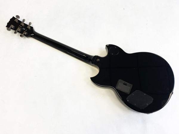 Black electric guitar back view showing neck, headstock with tuning pegs, and rear electronics cavity covers on white background