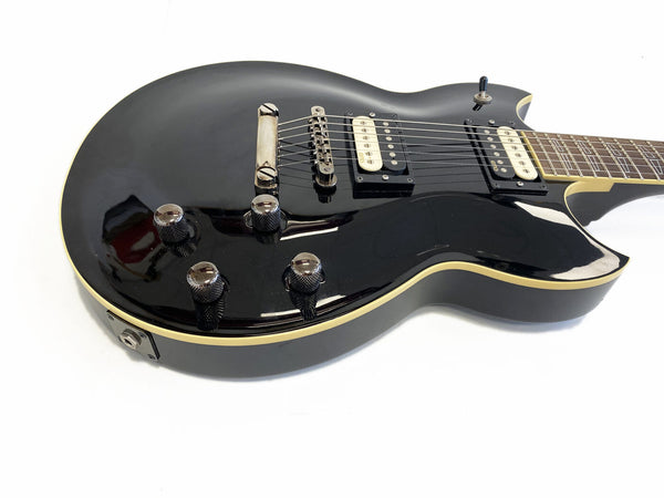 Black electric guitar with cream binding, dual humbucker pickups, and chrome control knobs on white background