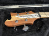 Rickenbacker bass guitar headstock with vintage wood finish and chrome tuning pegs in black plush guitar case