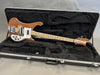 Rickenbacker bass guitar with wooden finish in black plush-lined hard case on gray background