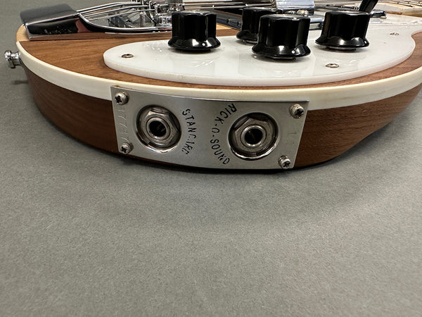 Close-up of vintage electric guitar input jack plate with "STANDBY" and "RICK-O-SOUND" labels and black control knobs on wooden body