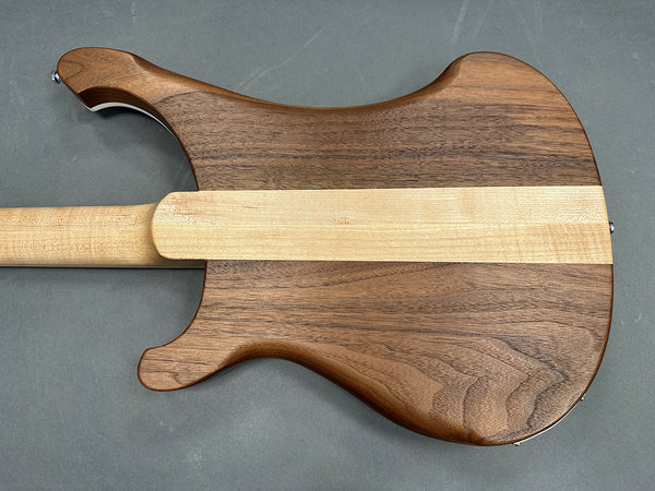 Back of electric guitar body with natural walnut wood and maple center stripe neck joint on gray background