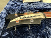 Close-up of vintage Rickenbacker bass guitar headstock with tuning pegs and strings on blue plush case lining
