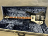 Rickenbacker black electric bass guitar with white pickguard and triangular inlays in open gray hardshell case with dark blue interior lining