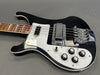 Black electric bass guitar with white pickguard, chrome bridge and pickup, four control knobs, and rosewood fretboard on gray background.