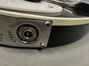 Close-up of guitar output jack plate with serial number 14528 and partial text STAMP R on black electric guitar body edge