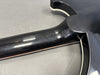 Close-up of black guitar neck joint and glossy finish with white binding detail on guitar body edge