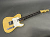 Vintage Fender Telecaster electric guitar with butterscotch blonde finish and white pickguard on gray background