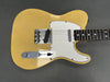Vintage yellow solid body electric guitar with white pickguard and chrome hardware