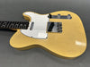 Vintage yellow solid body electric guitar with white pickguard, chrome bridge, and black rosewood fretboard on gray background