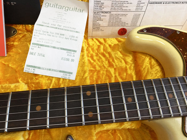 Close-up of Fender Custom Shop 2018 NAMM LTD Roasted 1960 Relic Strat Vintage White electric guitar fretboard and body with receipt and electronics notes on yellow fabric backdrop